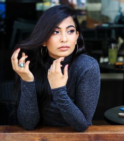 Thoughtful young woman leaning on railing