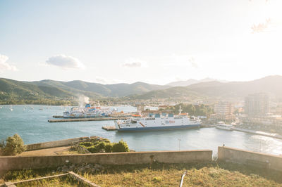 Boats in sea with mountain range in background