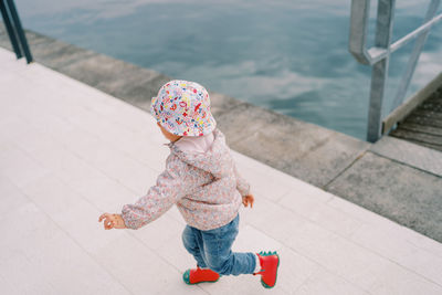 Portrait of cute girl standing on footpath