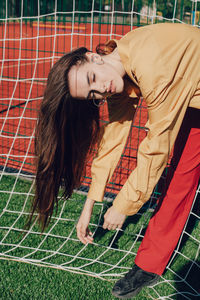 Young woman standing by soccer goal