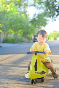 Portrait of cute boy riding motorcycle on road