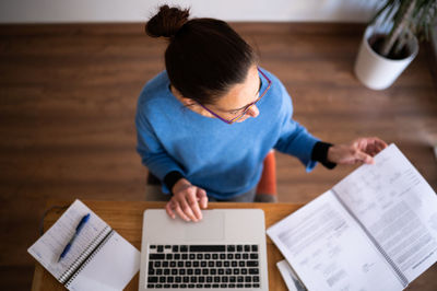 High angle view of boy drawing on book
