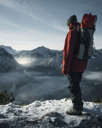 Germany, bavaria, ammergau alps, teufelstattkopf, tourist hiking in mountains on winter day