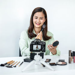 Portrait of smiling young woman using mobile phone in laboratory