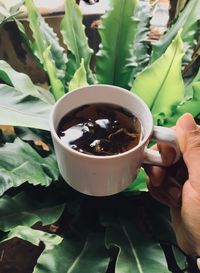 High angle view of hand holding coffee cup