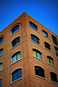 Low angle view of office building against blue sky