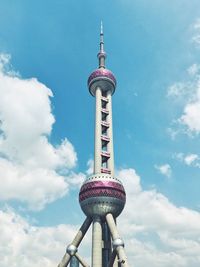 Low angle view of communications tower against cloudy sky