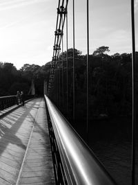 People on footbridge against sky