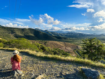 Rear view of woman walking on mountain against sky on the margarita island in venezuela 