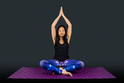 Woman wearing mask against black background