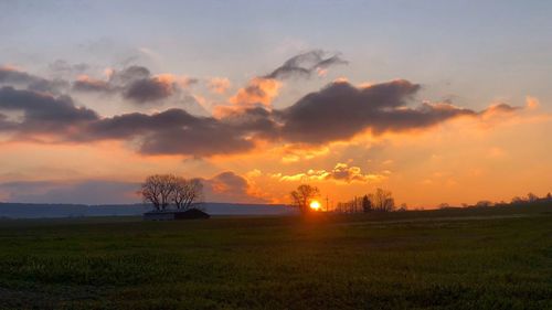 Scenic view of silhouette field against sky during sunset