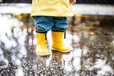 Low section of woman standing on puddle