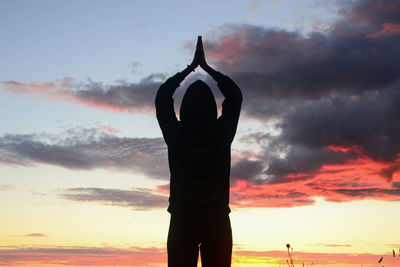 Rear view of silhouette person standing against sky during sunset