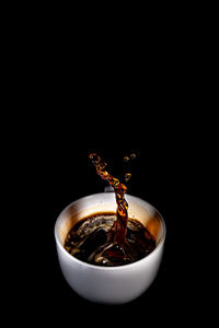 Close-up of coffee cup against black background