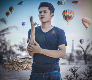 Portrait of young man gesturing while standing outdoors