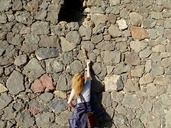 Rear view of woman standing on cobblestone