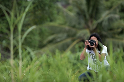 Full length of woman photographing outdoors