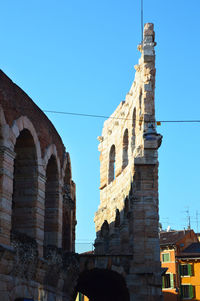 Low angle view of historical building against clear blue sky
