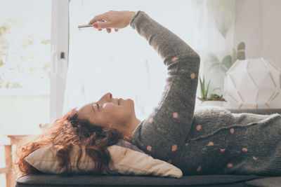 Young woman lying on bed at home