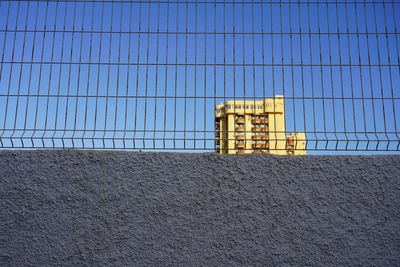 Plattenbau, industrialized apartment block behind wall and metal fence 