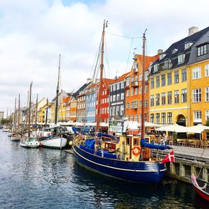 Sailboats moored on canal against buildings in city