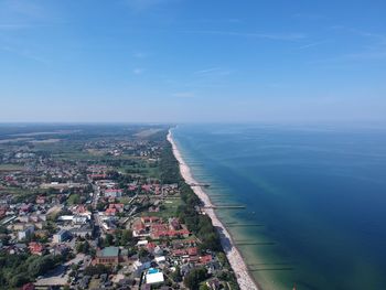 High angle view of buildings by sea against blue sky