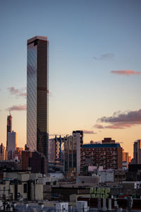 Buildings in city against sky during sunset
