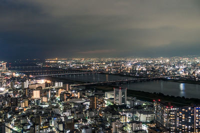 High angle view of illuminated buildings against sky at night