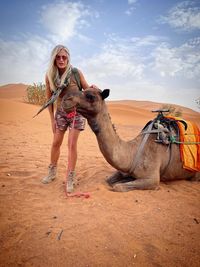 Side view of camel on sand at desert