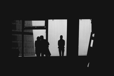 Silhouette people walking in corridor of building