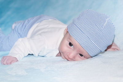 Portrait of cute boy lying on bed