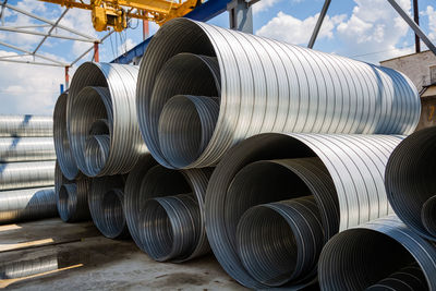 Stack of pipes against sky