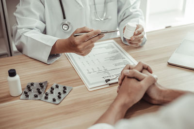 Midsection of doctor examining patient at clinic