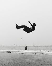 People on beach against clear sky