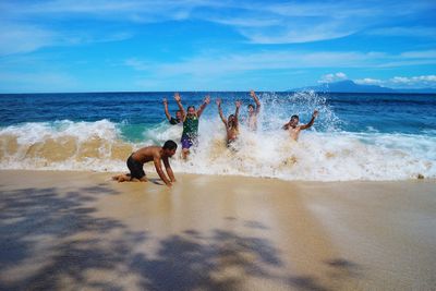 People at beach against sky