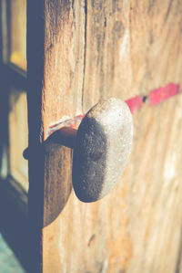 Close-up of rusty metal hanging on wood