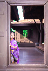 Portrait of girl standing at entrance of building