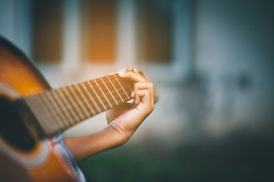 Midsection of man playing guitar