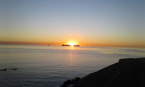 Scenic view of sea against clear sky during sunset