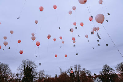 Low angle view of balloons flying against sky