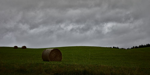 Hay bales on field against sky