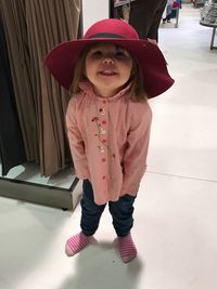 Portrait of cute girl wearing hat standing at store