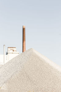 Chimney by sand against clear sky