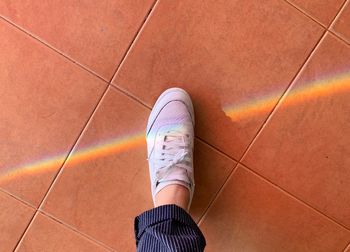 Low section of woman standing on tiled floor