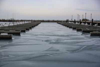 Pier over sea against sky during winter