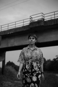 Portrait of woman standing against bridge