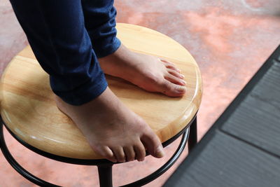 Low section of woman standing on stool at home