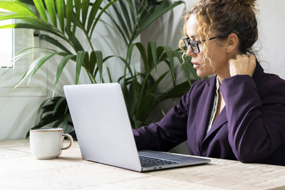 Businesswoman using laptop at table