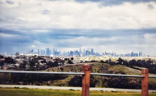 View of cityscape against cloudy sky