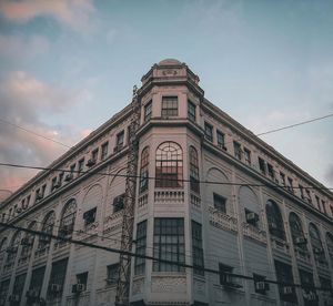 Low angle view of building against cloudy sky